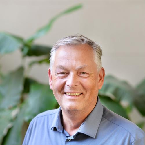 A smiling missionary man in blue wear serving global mission work in New Zealand outdoors. OM New Zealand