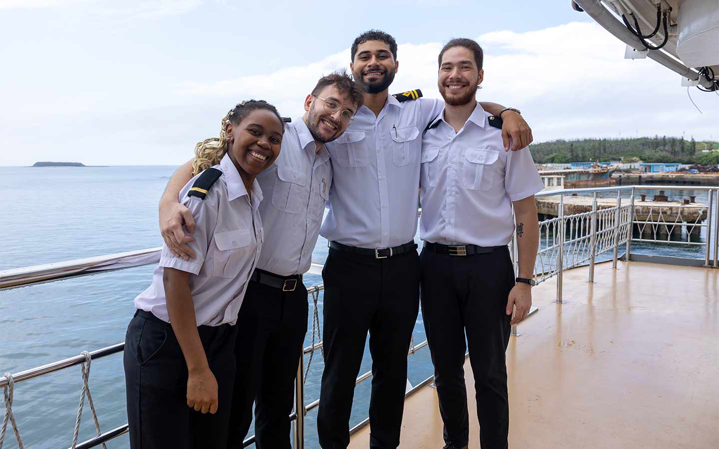 New Zealand missionaries smiling on ship deck, serving globally in Gospel outreach ministry. OM New Zealand