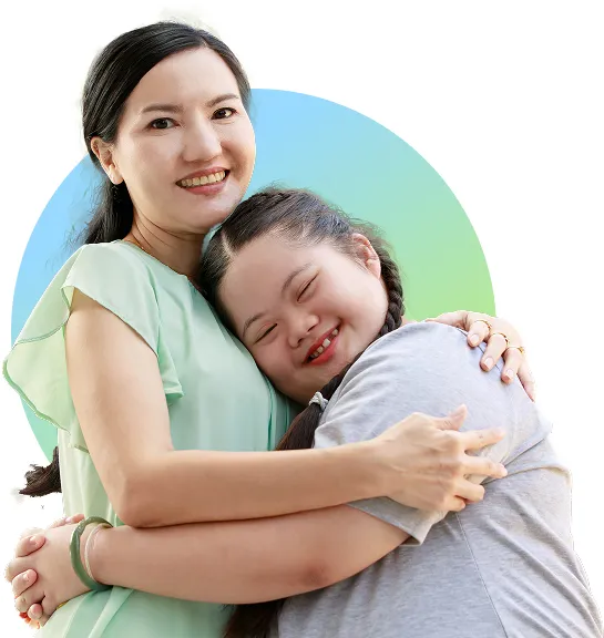 Asian mother embracing her autistic daughter who is hugging her tightly