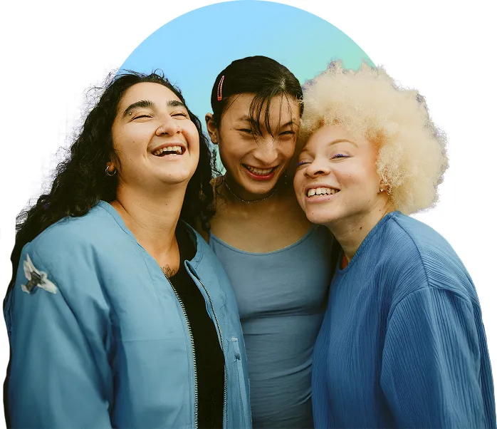 Three disabled woman of varying ethnicities smiling together as friends