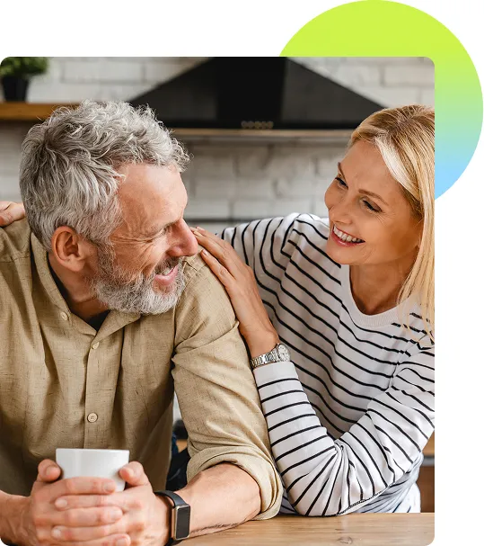A mature couple sitting together inside their home and talking with each other