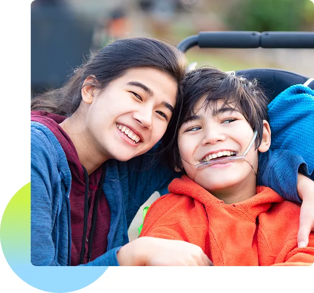 Sister smiling and posing with her disabled little brother