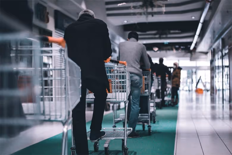 Shoppers with trolleys waiting in line