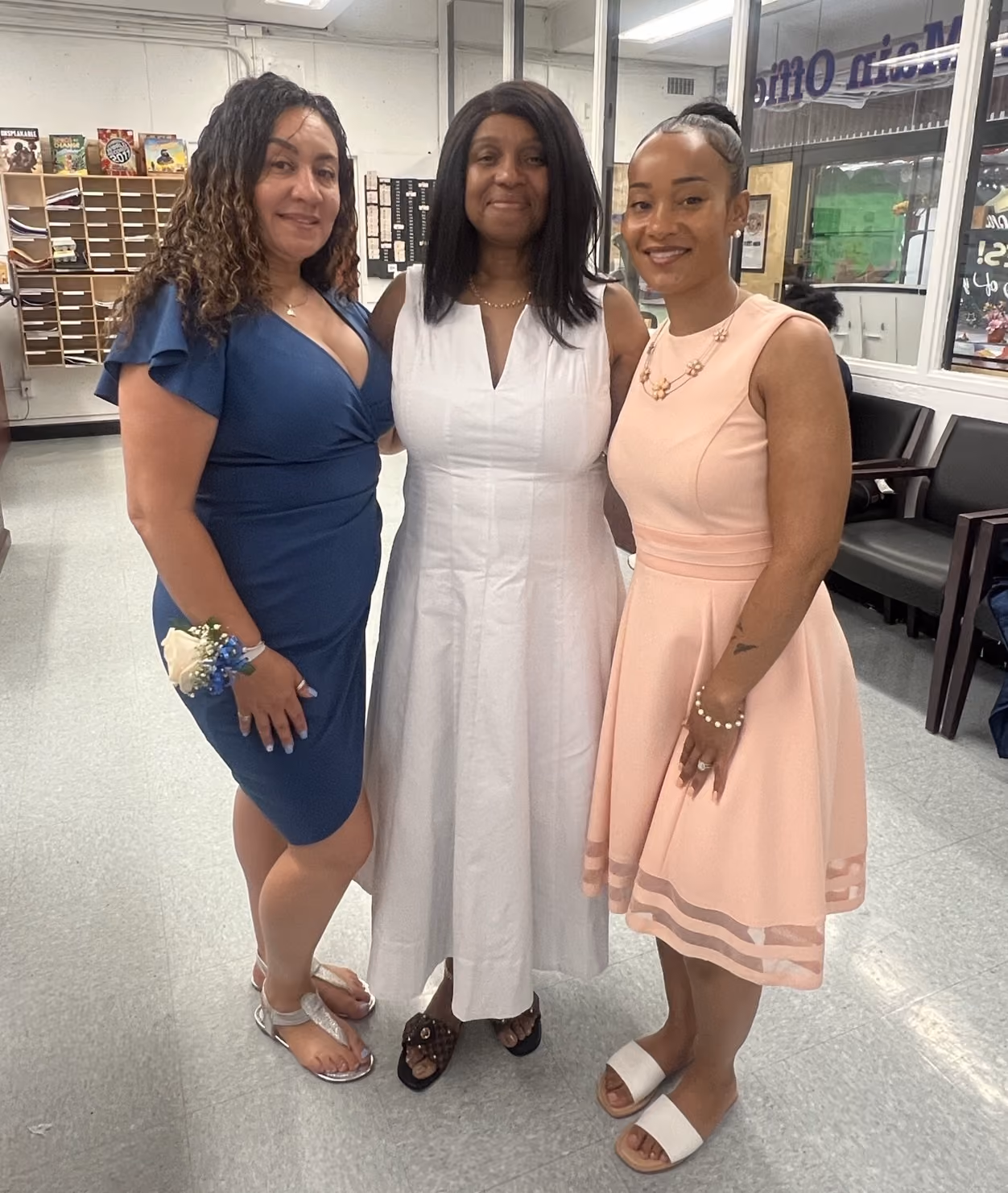 Three women dressed up posing together near school main office