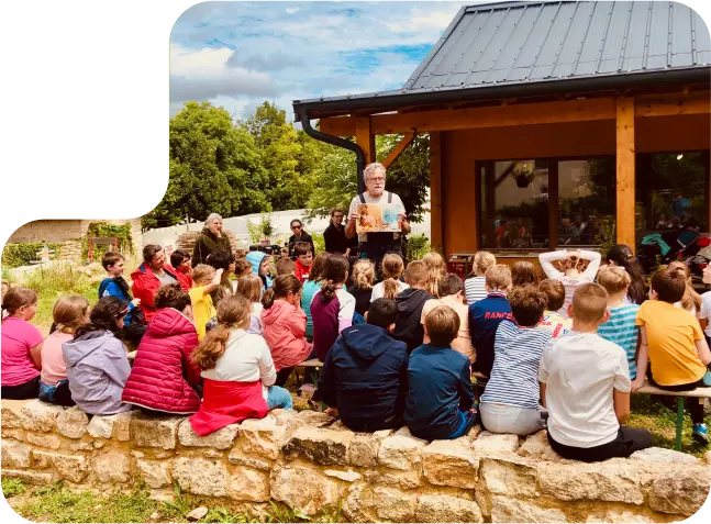 classe en extérieur écoutant une présentation d'un adulte