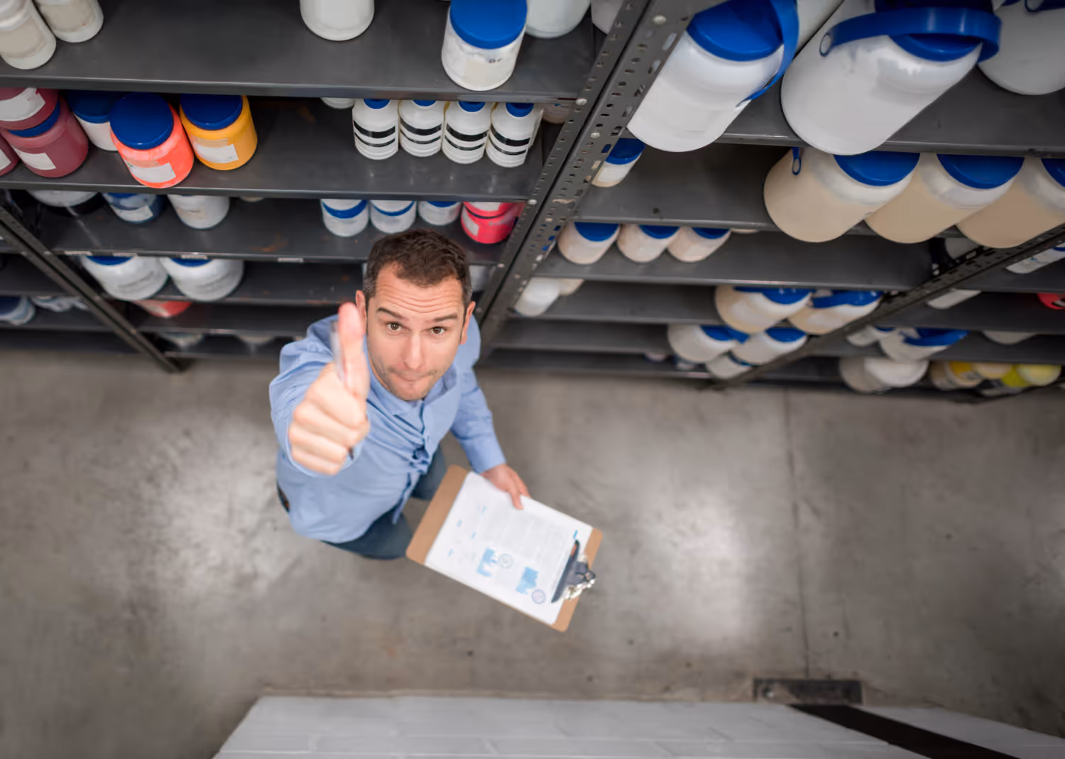 A warehouse worker with their thumb up at the camera
