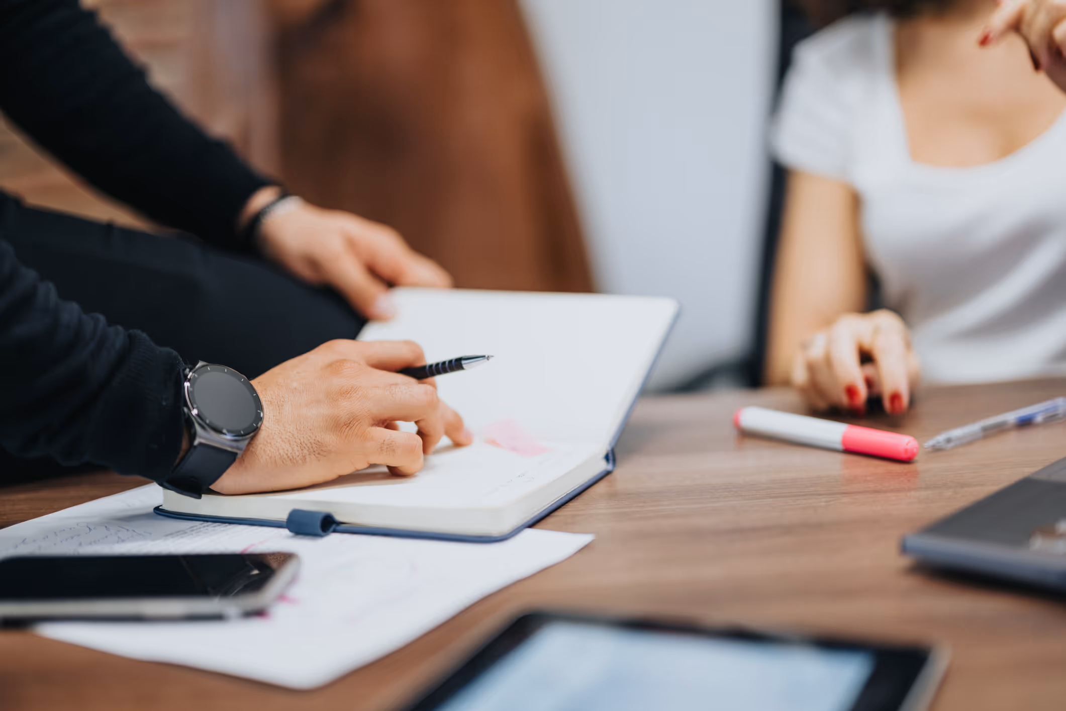 Someone taking notes in a meeting