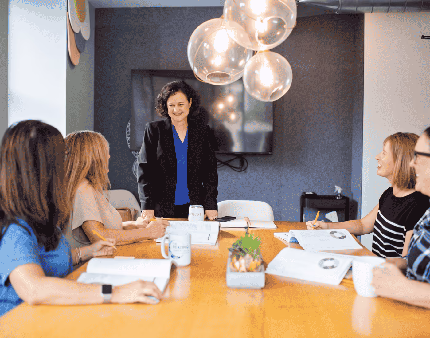 Stephanie gathered with a group of teachers around a table, chatting and working together