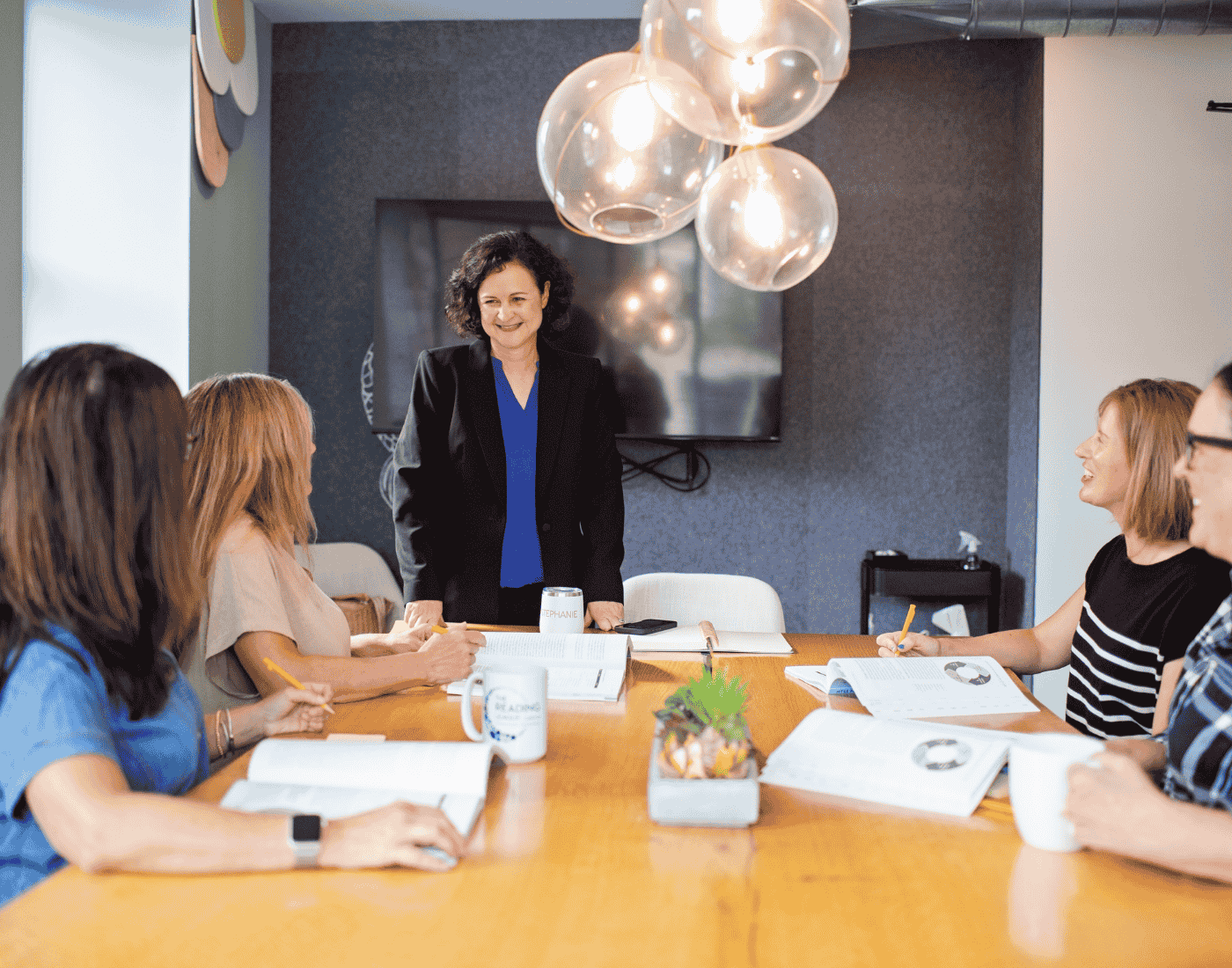 Stephanie gathered with a group of teachers around a table, chatting and working together