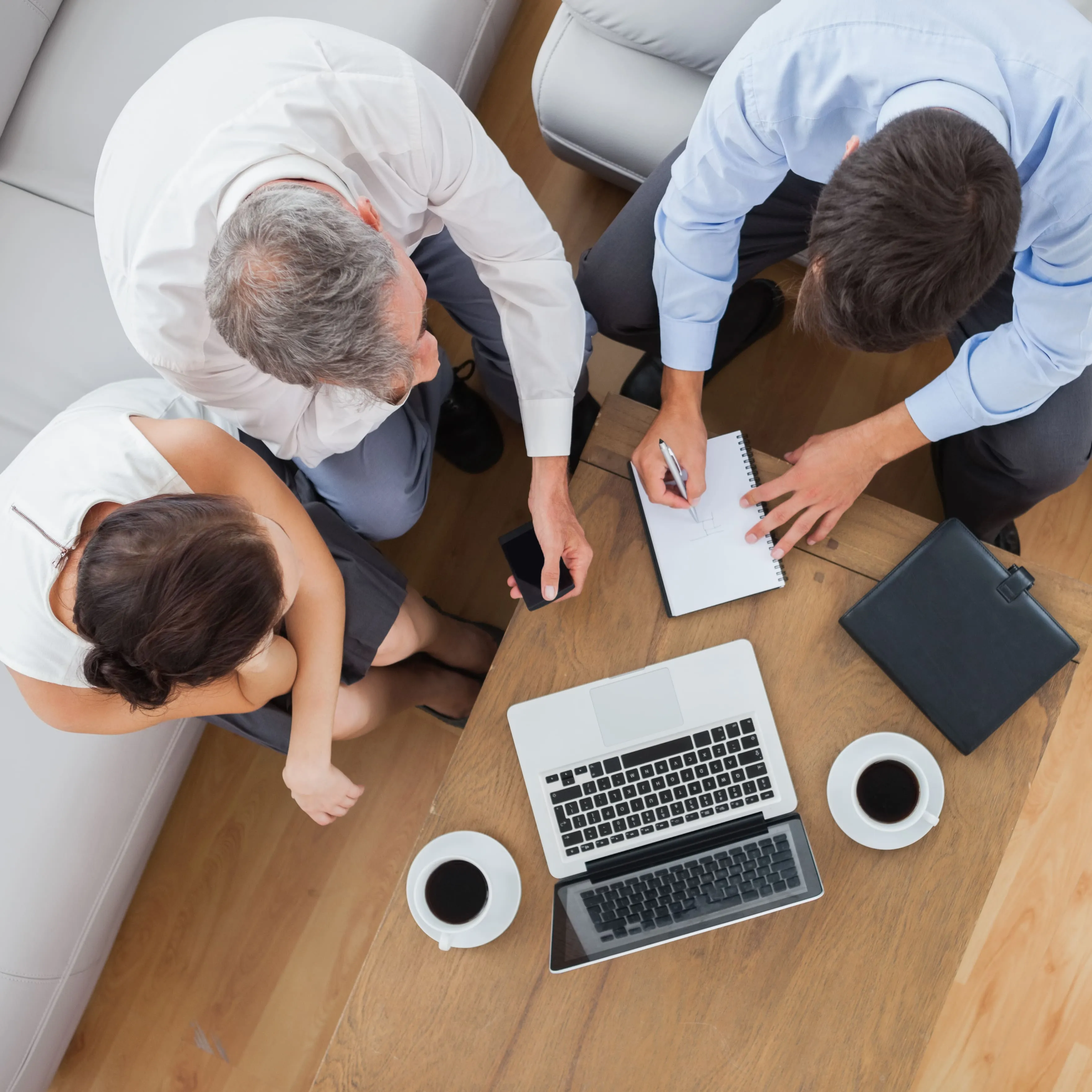 Tres personas trabajando frente a laptop