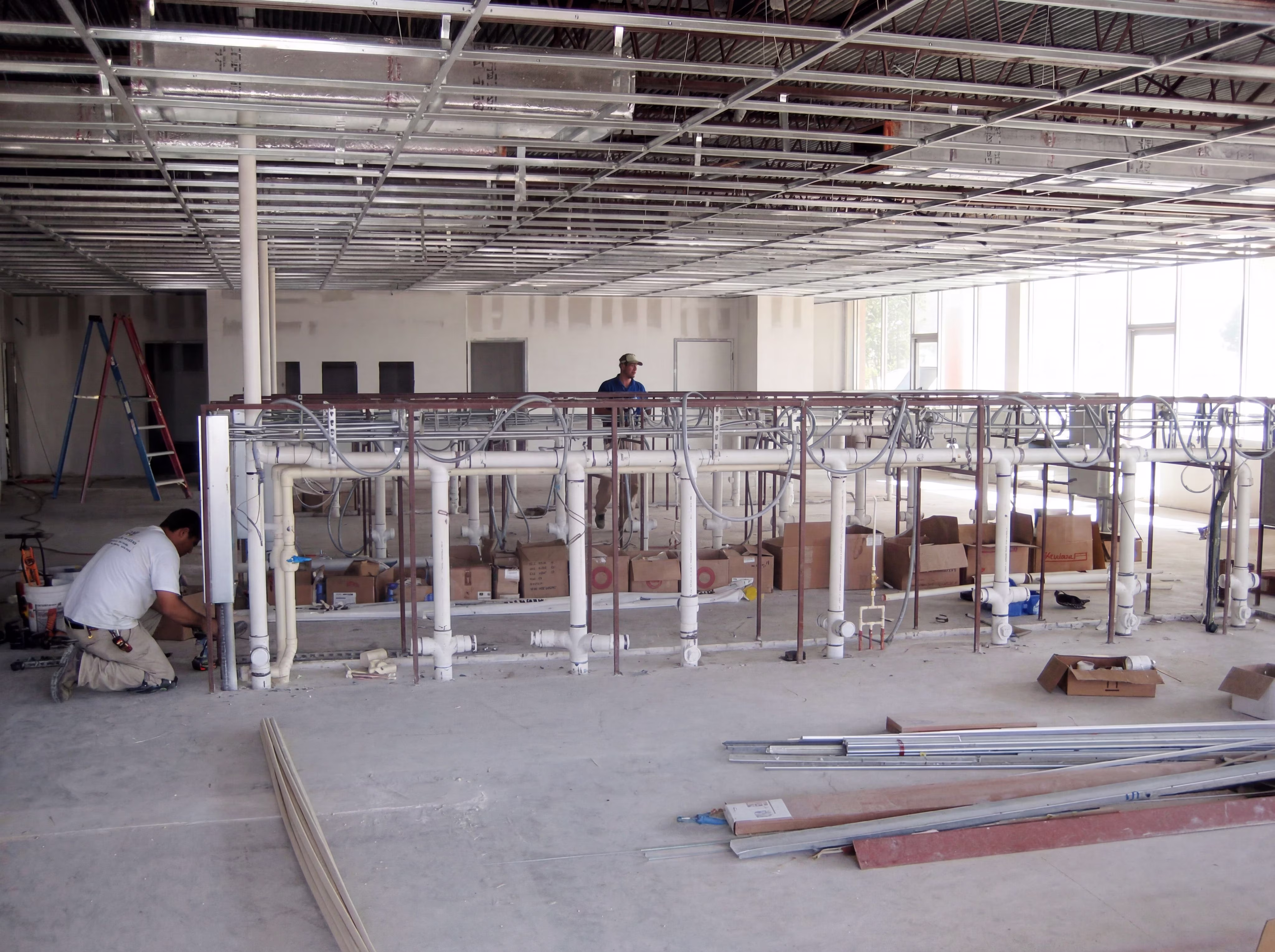 a laundromat under construction with drain pipes and water lines installed