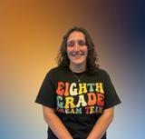 Ms. Dey smiling in an Eighth Grade Dream Team shirt