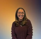 Ms. Ortiz smiling in a maroon sweater and glasses