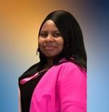 Ms. Cribbs smiling in a pink blazer staff portrait