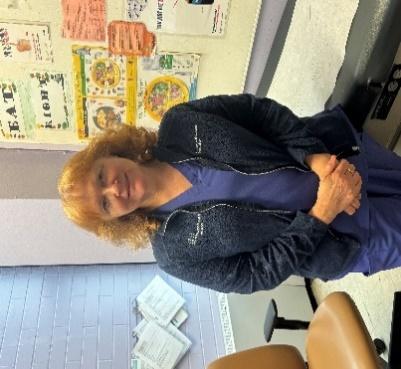 Ms. Baird standing in her classroom with arms crossed