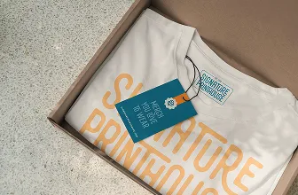 a white shirt in a box with a tag for Signature Printhouse 