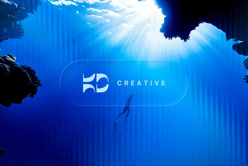 a person swimming under water with KD Creative logo