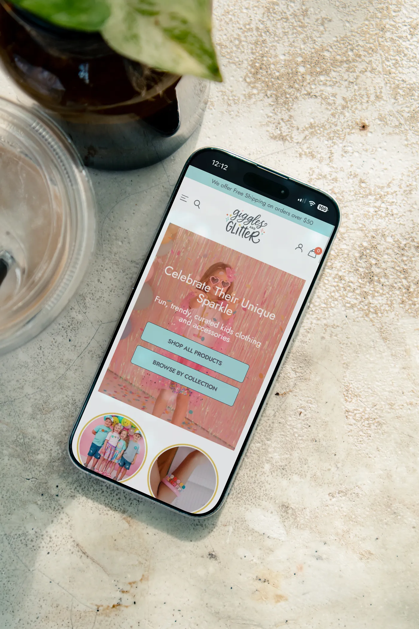 A phone on a flat surface with the Giggles and Glitter website.