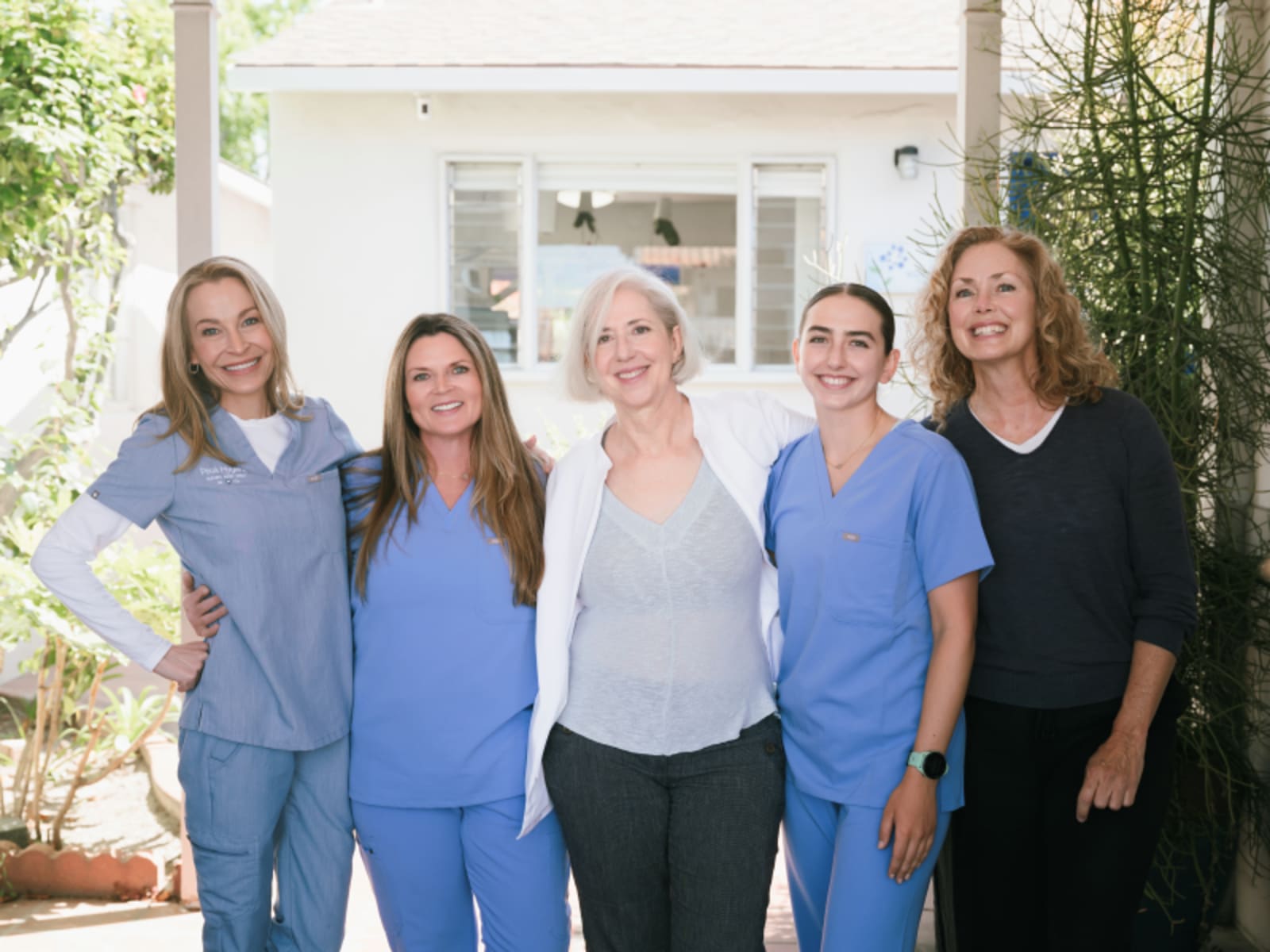 Team of dental professionals standing together outdoors