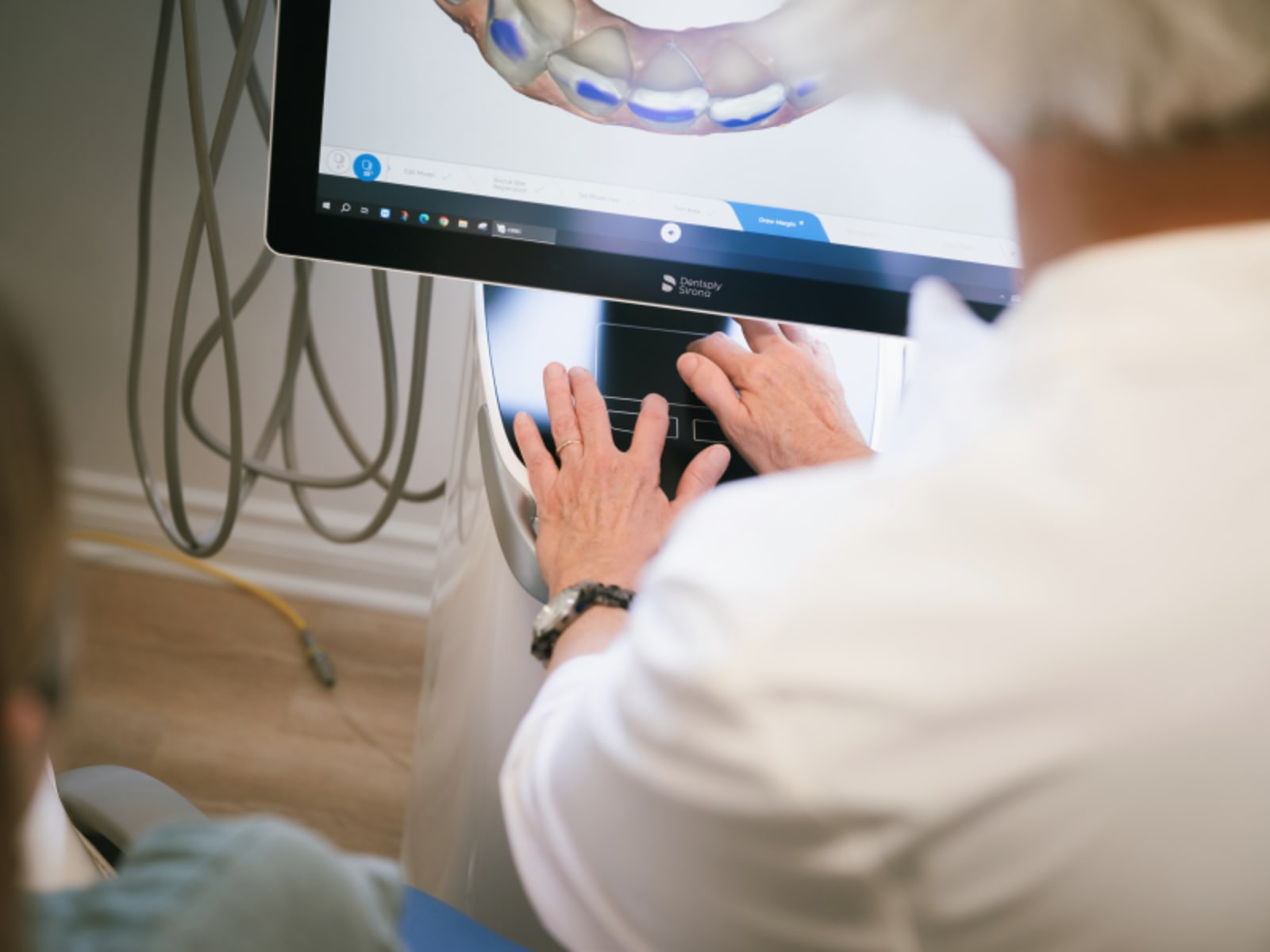 Dental professional showing X-ray or scan results to patient during consultation