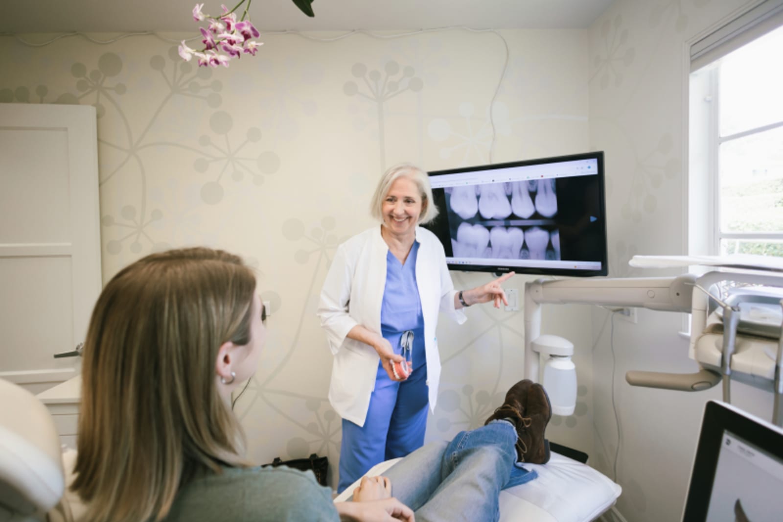 Dentist discussing dental treatment materials and options with patient at clinical workstation