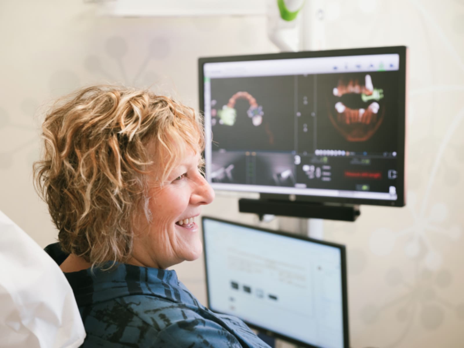 Dental professional reviewing digital imaging and radiographs on computer screen with patient