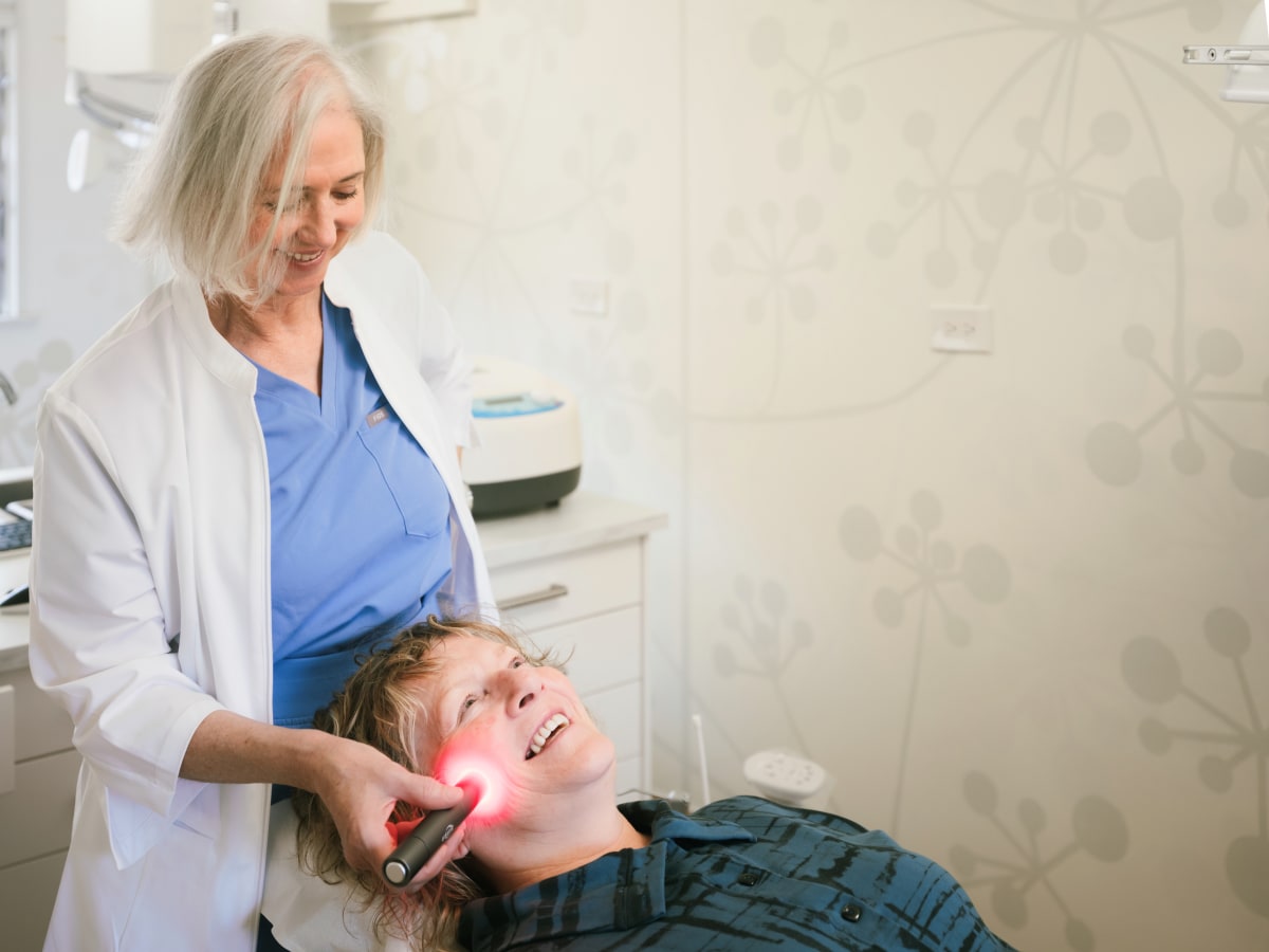 Dentist examining a patient in the treatment chair during a consultation