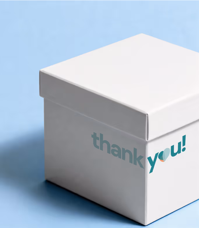 White gift box on a light blue background with the words 'thank you!' partially visible on its side.
