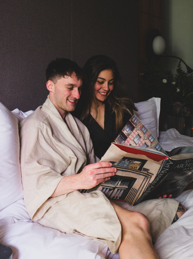 pareja disfrutando de una comoda habitacion de colima 71 mientras leen un libro en la cama 