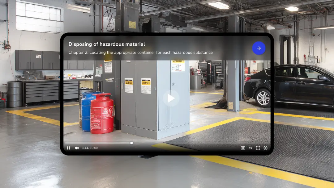 A digital tablet displays a video tutorial on disposing of hazardous materials. The video shows a large automotive repair shop or garage. Gray metal cabinets and storage units are visible, along with several large, colored containers that likely hold hazardous substances. A title bar at the top of the screen displays "Disposing of hazardous material" with a subtitle "Chapter 2: Locating the appropriate container for each hazardous substance."