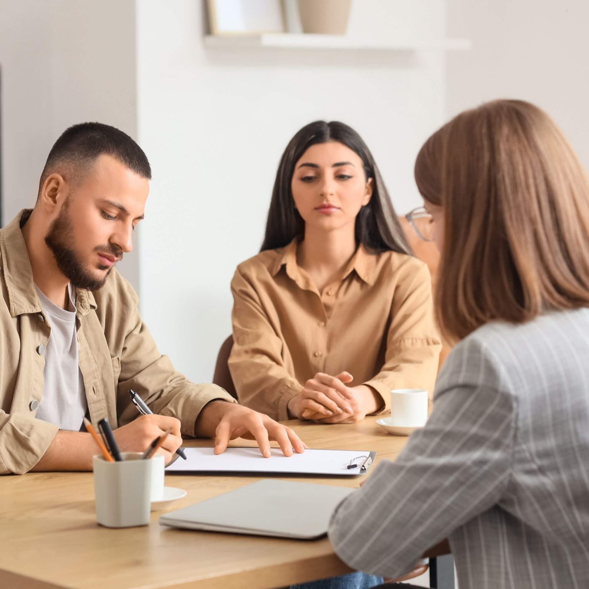 Parents seated at a table meeting with a family law mediator or attorney during a legal consultation.
