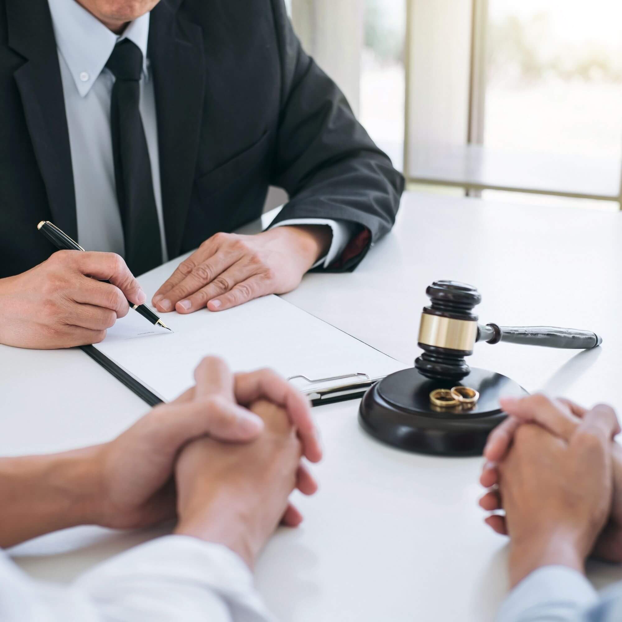 Attorney reviewing documents with two individuals seated across a desk in a legal office
