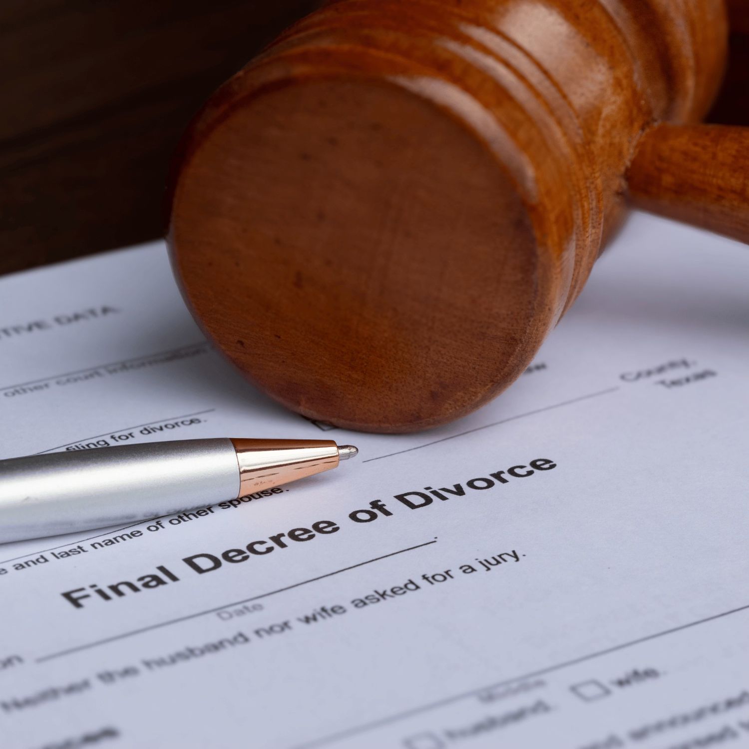 Wooden judge’s gavel resting on a finalized divorce decree document.