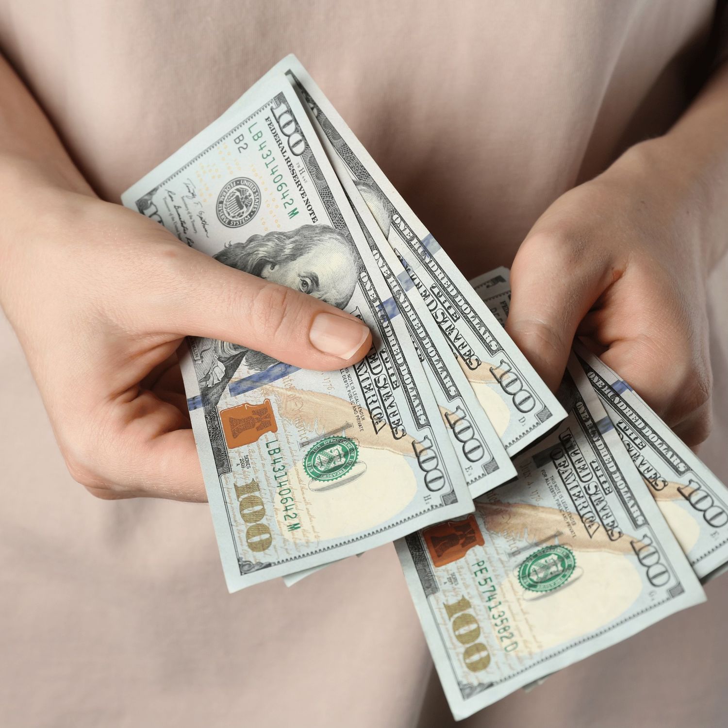 Hands holding and counting U.S. hundred-dollar bills