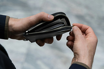 Close-up of a person opening a wallet, symbolizing employee reimbursements and expense management in service businesses.