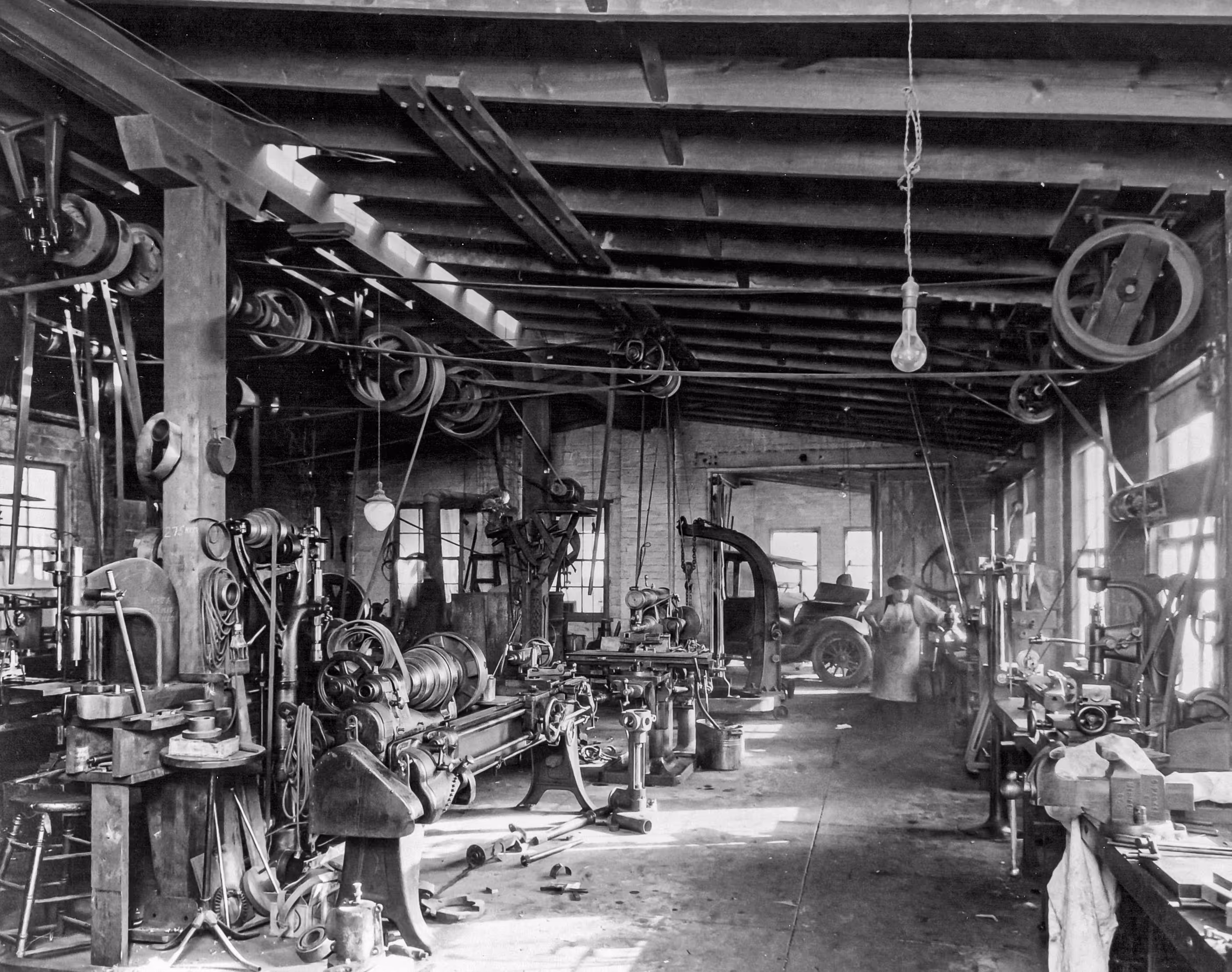 Early 20th-century Burns Machine Company workshop with belt-driven lathes and machining equipment.