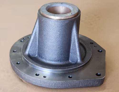 CNC machined cast metal housing with tapered cylindrical extension and bolt holes by Burns Machine Company.