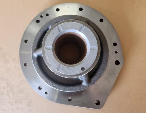 Precision CNC machined circular housing with central bore and bolt holes by Burns Machine Company.