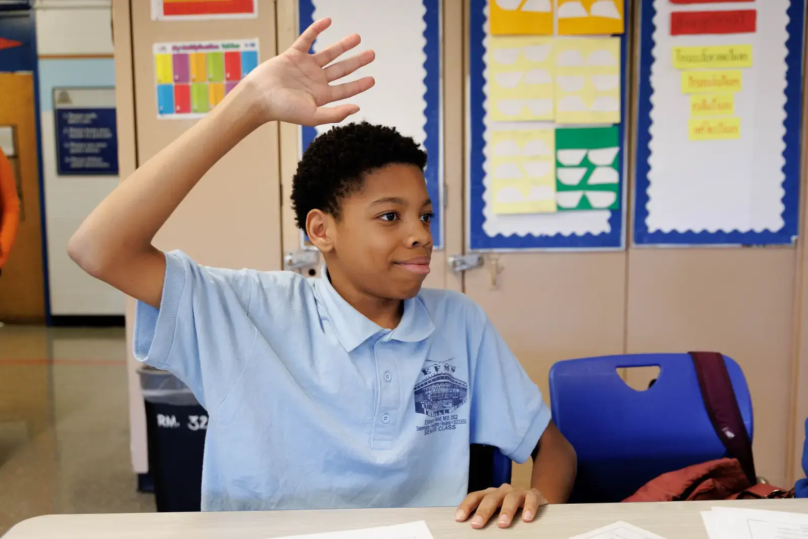 Student raising hand to answer a question in class