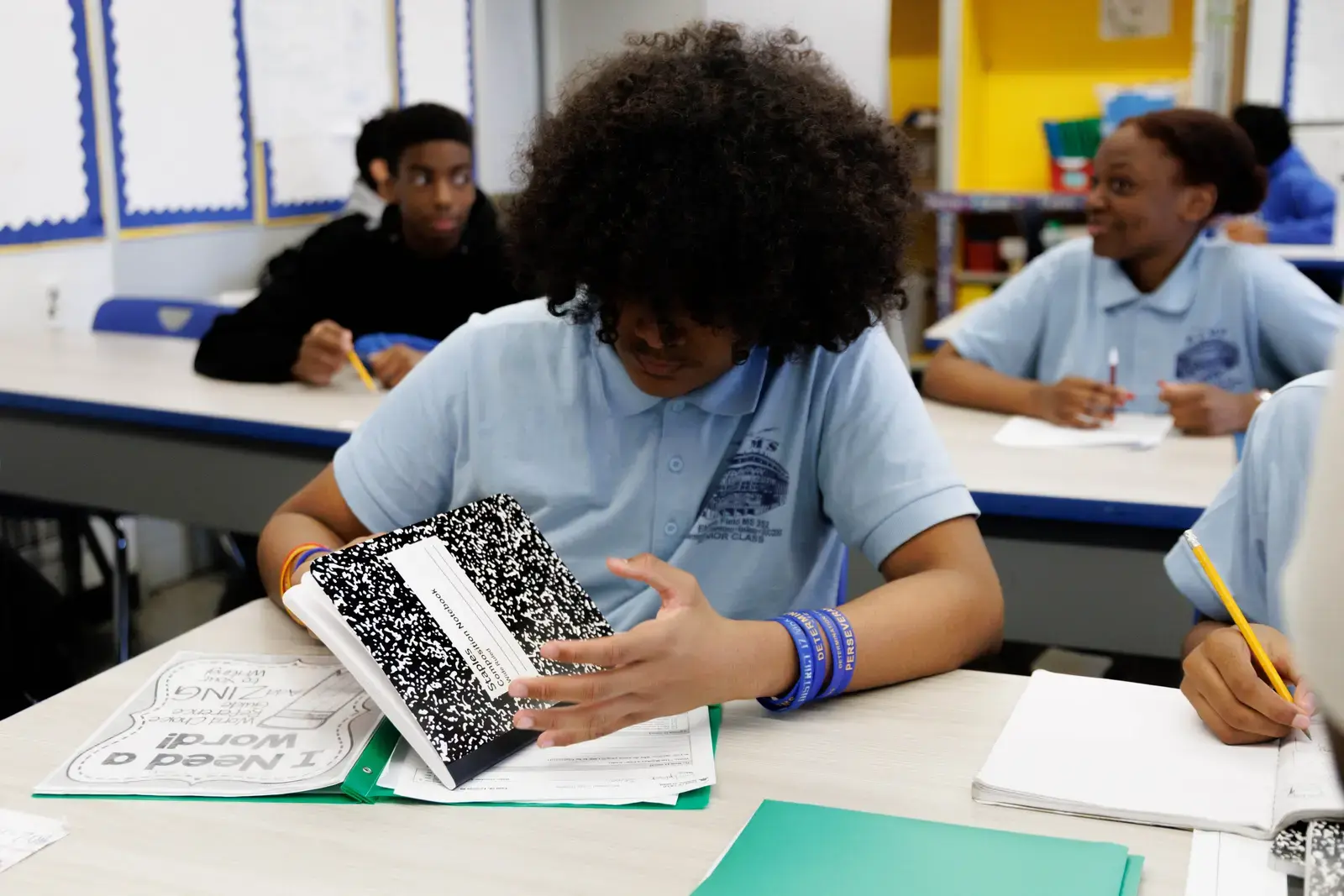 Middle school students in uniform working at classroom desks