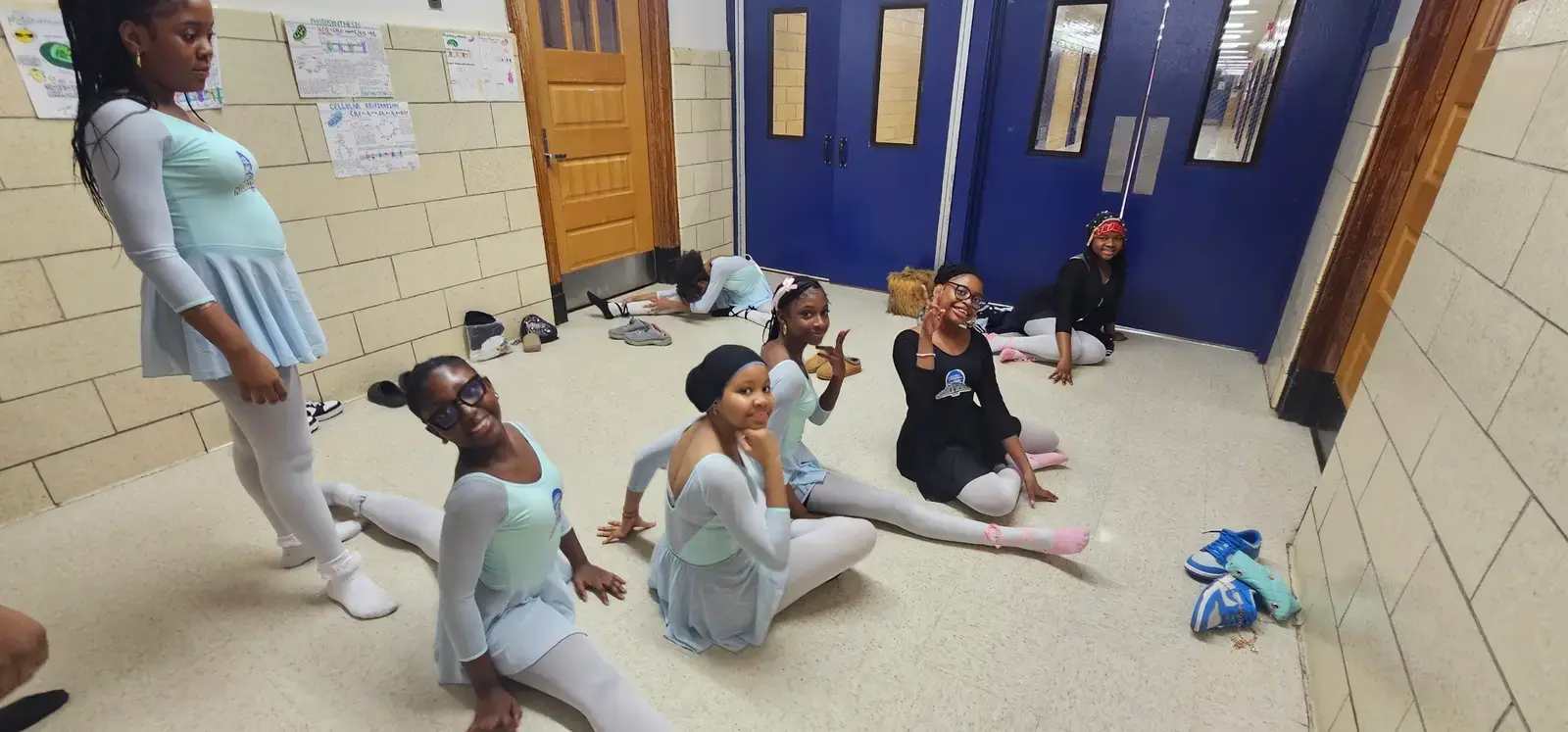Student dancers stretching in hallway before ballet performance