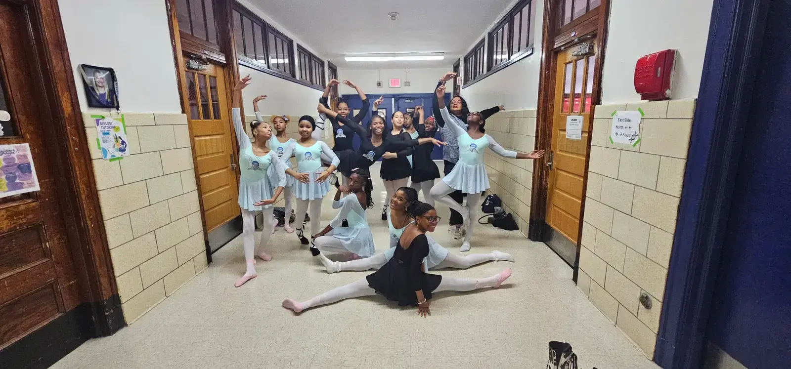 Student ballet dancers posing in school hallway in costume