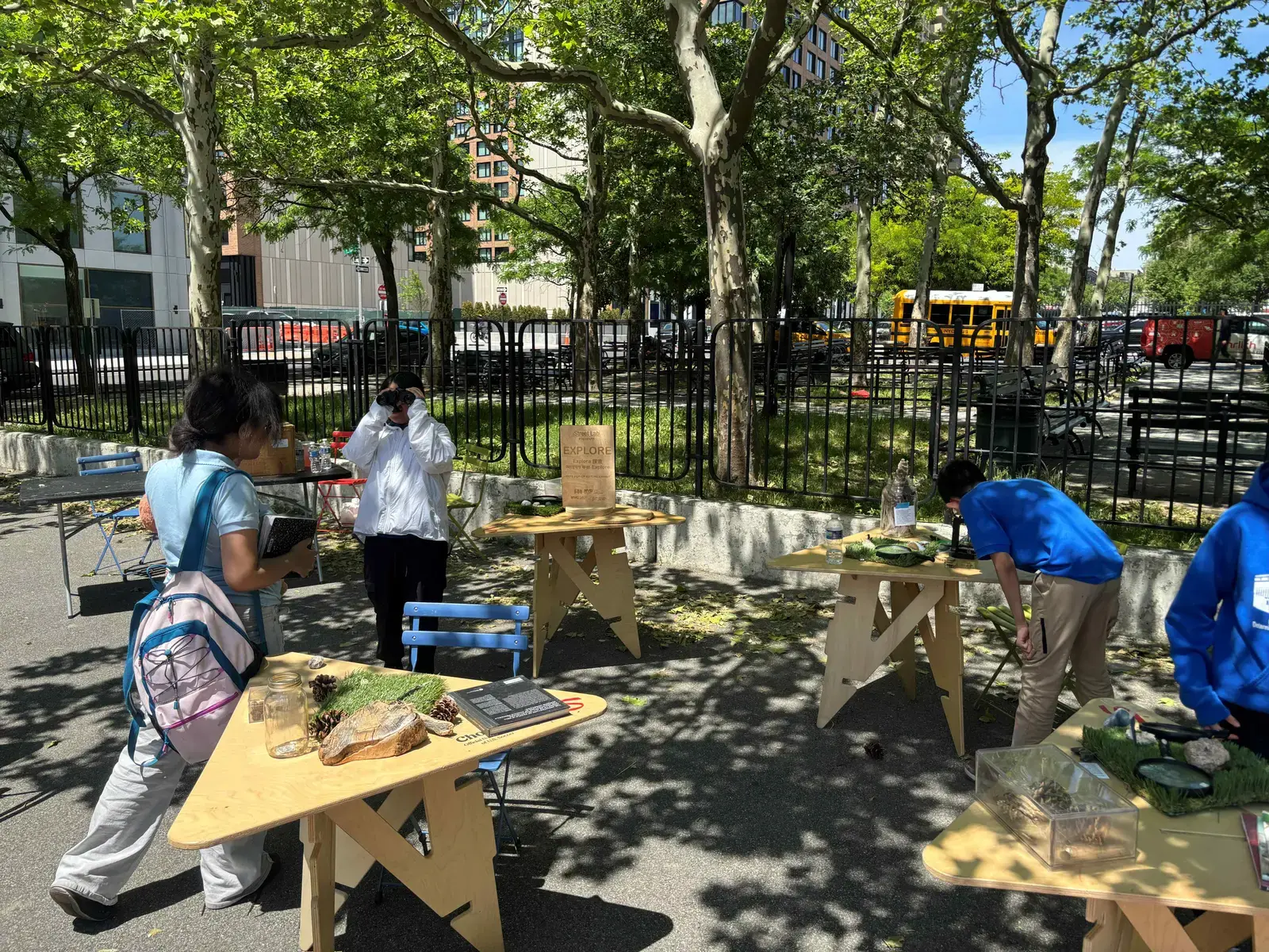 Students exploring outdoor nature activity tables during a school event