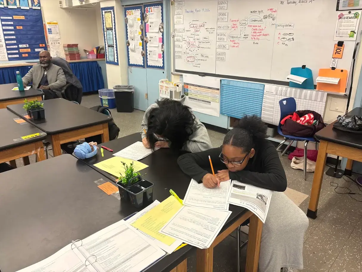 Students working on worksheets at classroom desks during science lesson