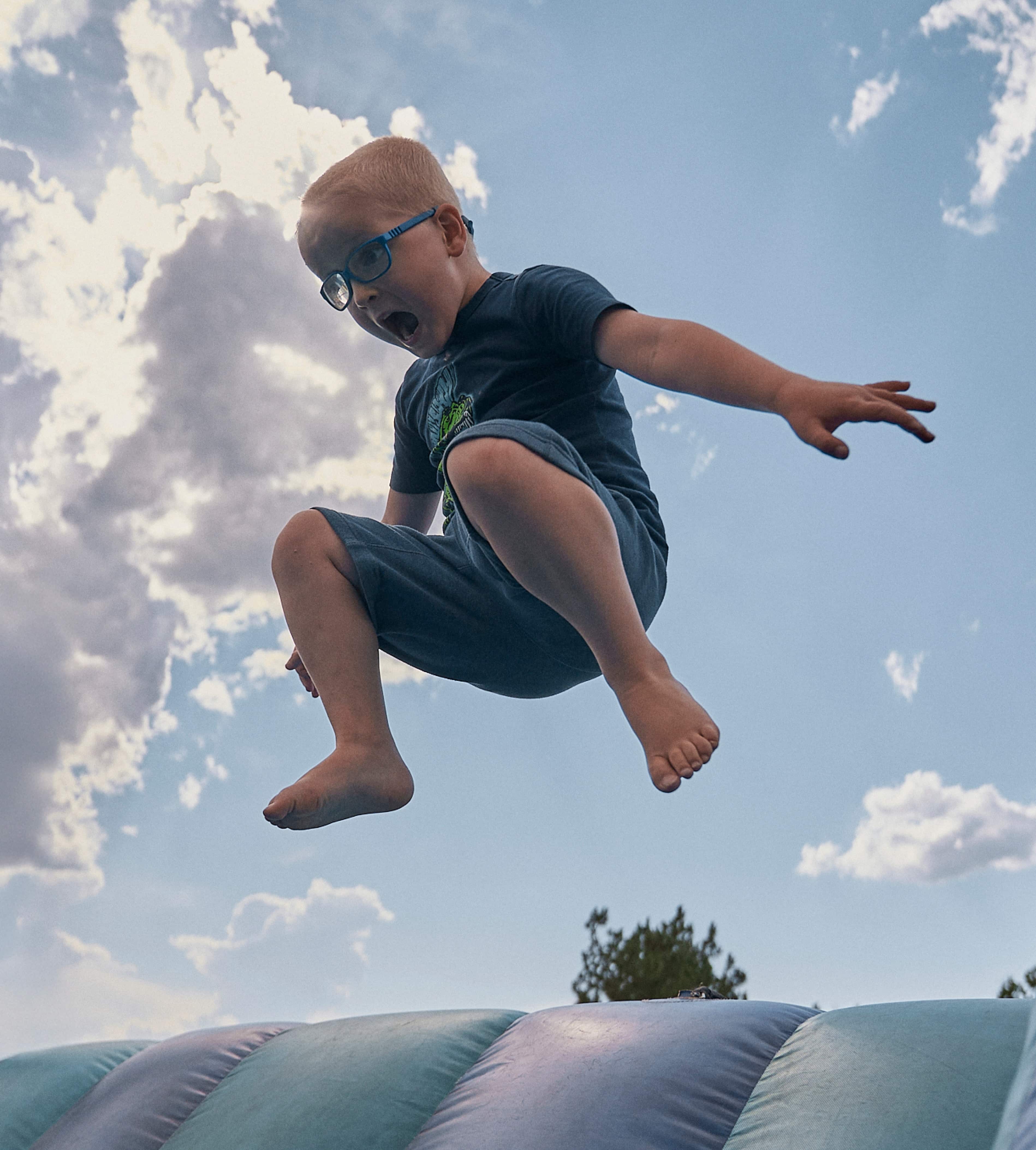 Boy jumping in the air off an air-maze slide!