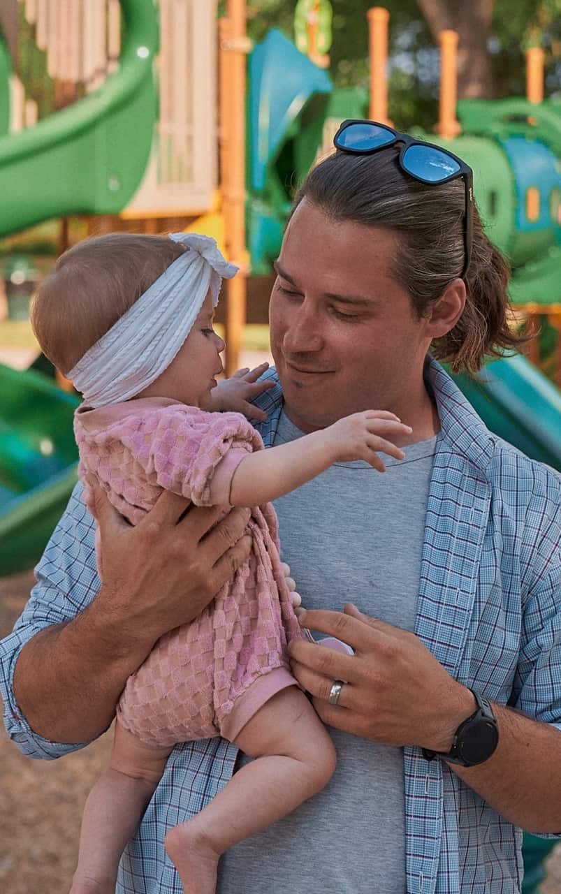 Father and daughter smiling at each other.