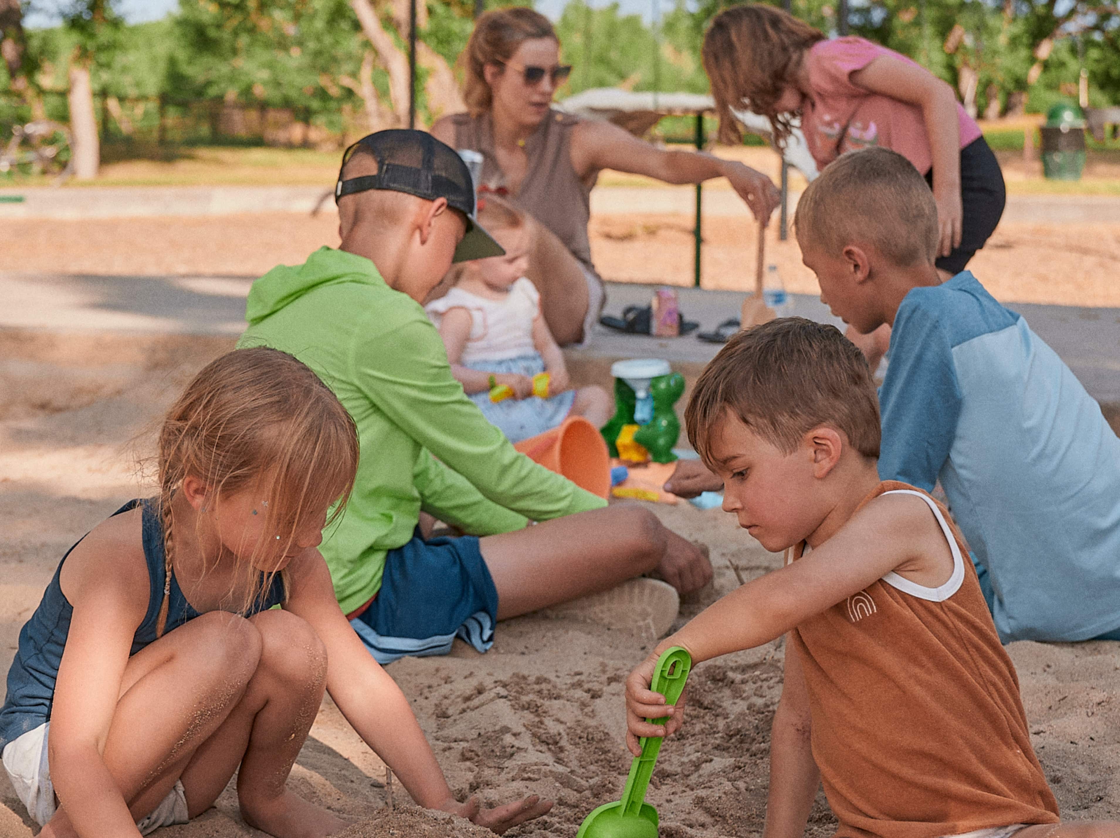 Kids playing in the sand together.