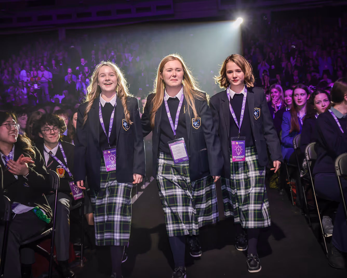 Three young women walking on stage to accept their award.