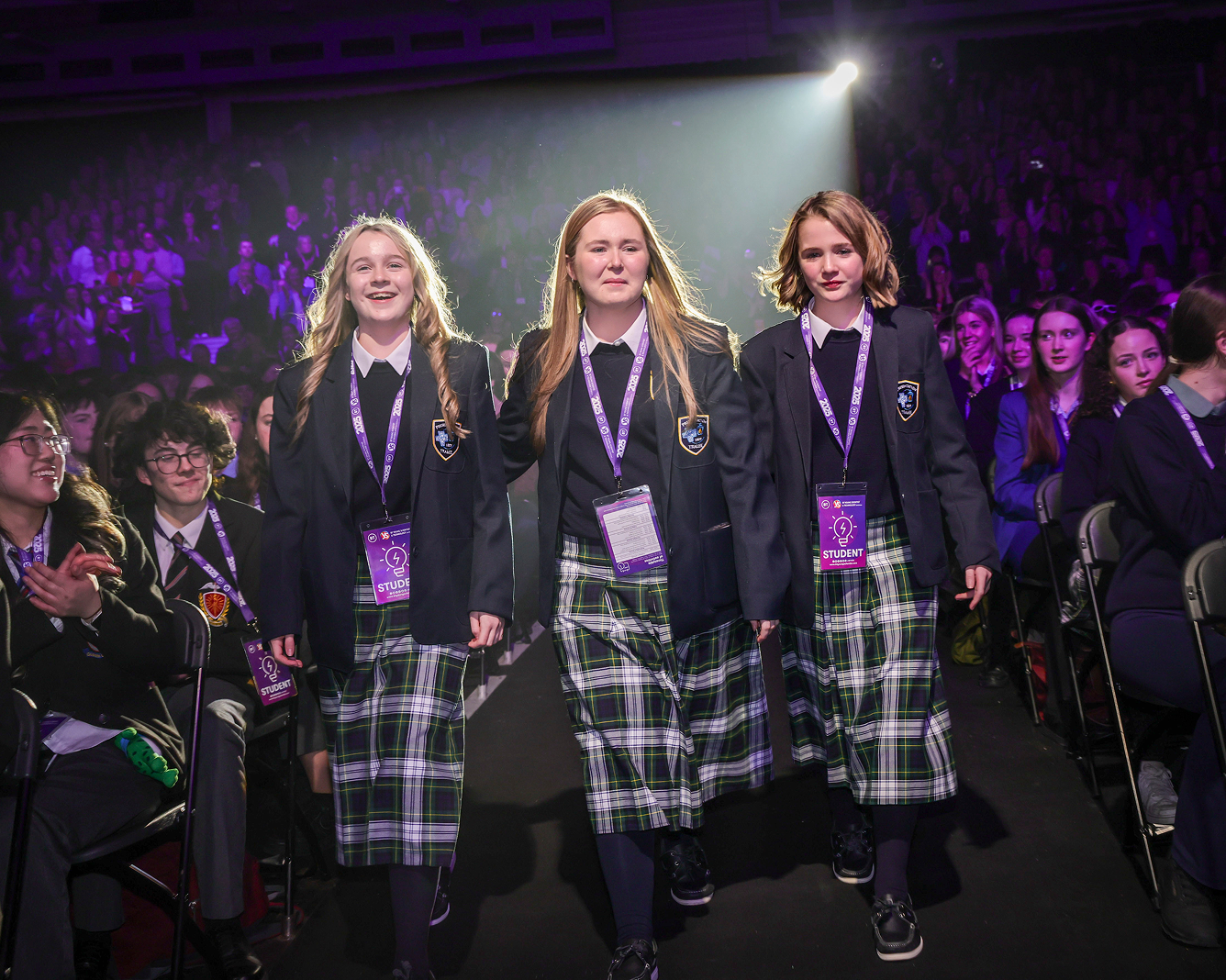 Three young women walking on stage to accept their award.