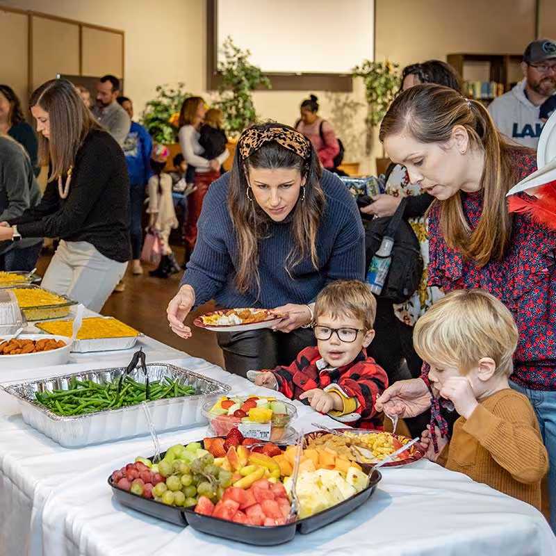 a group of people are eating at a table